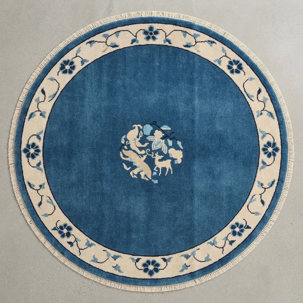 Cobalt Blue Round Hand-Knotted Rug with Ivory Floral Vine Border - studio photo