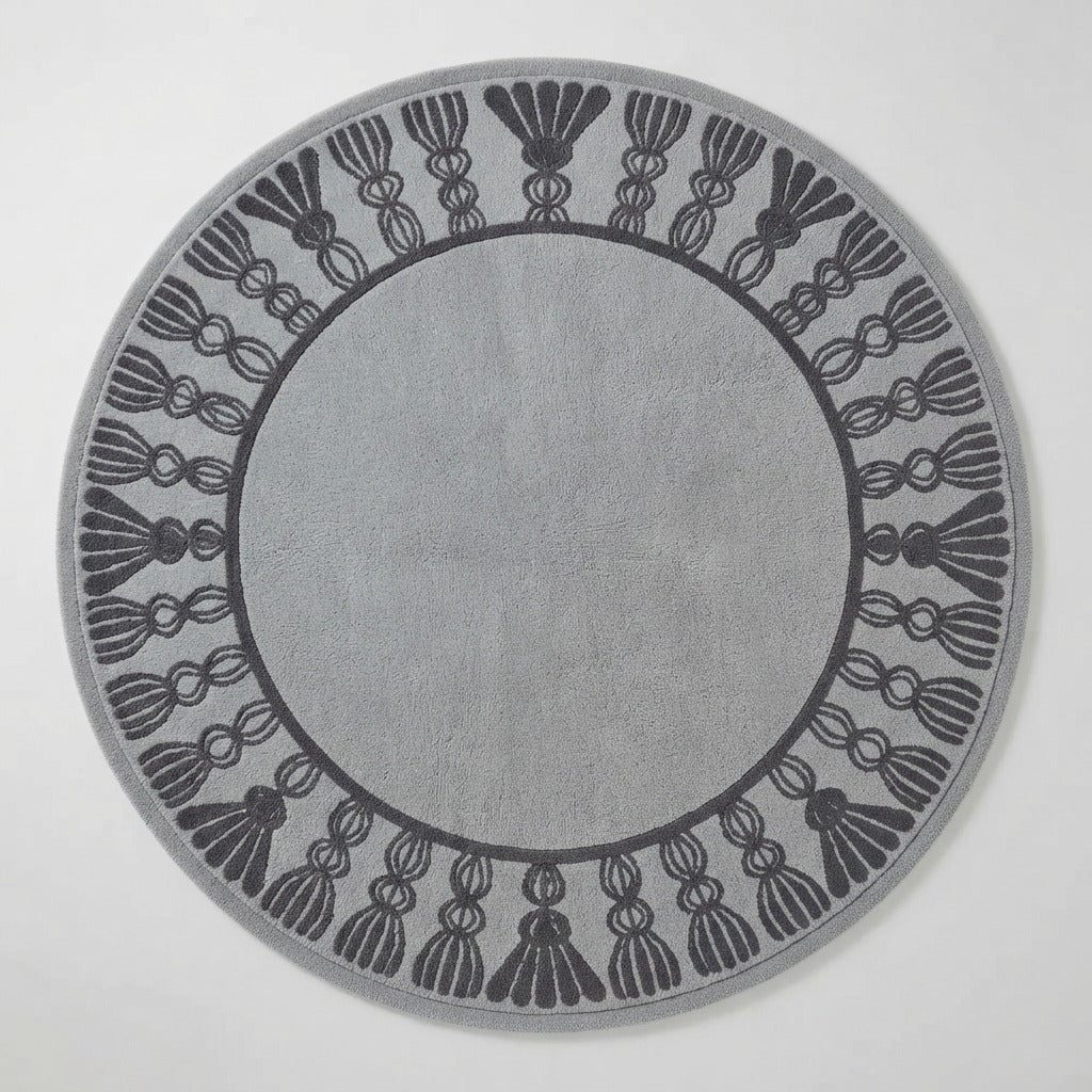 Grey Round Hand-Tufted Rug with Charcoal Tassel Border - studio photo